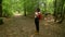 Teenage African American mixed race girl young woman hiking with red backpack and taking photographs  in forest woodland