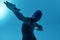 Teenage african boy sportsman in swimming cap and goggles having swim training while standing  over blue