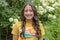 Teenage Amerasian female standing before a beautiful bed of flowers in Bar Harbor, Maine.