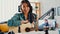 Teenage Asia girl influencer play guitar music use microphone record with smartphone for online audience listen at home. Female