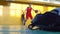 A teenage basketball player is training in the school sports hall.