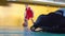 A teenage basketball player is training in the school sports hall.