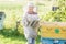 Teenage beekeeper checking hives on bee yard