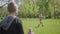 Teenage blond boy playing frisbee in the park with his mother. The child throwing the toy but woman does not catch it