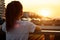 Teenage blonde with long hair in ponytail admires sunset