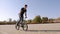 Teenage BMX rider is performing tricks in skate park.