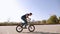 Teenage BMX rider is performing tricks in skate park.