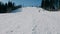 Teenage boy of 12 years in grey suit sliding on a snowboard from snow descent next sky lift. View from afar.