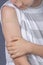 Teenage boy with adhesive bandage plaster on his arm after vaccination on blue background. Injection covid vaccine