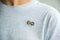 Teenage boy with autism infinity rainbow symbol sign metallic pin brooch on t-shirt. World autism awareness day, autism