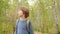 Teenage boy with backpack walking in beautiful forest.