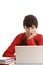 Teenage boy behind desk with laptop