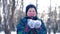 Teenage boy blowing snow from his hands.