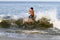 Teenage boy boogie boarding in the surf and waves for some summertime fun and masterful tricks including flips, turns and big air