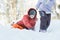 Teenage boy chasing after his sibling sister outdoors on snow hill