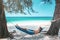 Teenage boy chilling in hammock on the beach