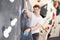 Teenage boy climbs steep artificial wall in sports complex and trains endurance