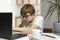 Teenage boy is engaged in programming. Child with glasses stares intently at the laptop monitor. Homeschool