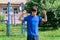 Teenage boy exercising outdoors, sports ground in the yard, he does a warm-up, healthy lifestyle