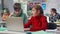 Teenage boy and girl study on laptop together sitting at desk in classroom
