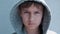 Teenage boy in gray hooded jacket looking directly to camera. Close up portret. 4k video