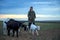 A teenage boy grazes goats in a field. A shepherd with goats in a field against a stormy sky.