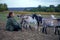 A teenage boy grazes goats in a field. A shepherd with goats in a field against a stormy sky.