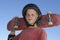 Teenage Boy Holding Skateboard Against Blue Sky