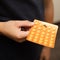 A teenage boy holds an orange pack of pill blisters in his hand. Panacea, medication, vitamins, healing from diseases, the concept