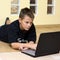 Teenage boy and laptop on floor