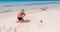 Teenage boy playing with little girl on tropical beautiful beach near the ocean