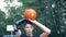 Teenage boy with a prosthetic hand is throwing a basket-ball.