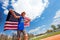 Teenage boy, race winner, running with flag of USA