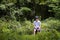 A teenage boy sits in the woods