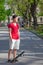 Teenage boy with skateboard standing in middle of street