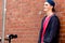 Teenage boy with skateboard standing next to the wall