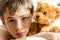 Teenage Boy Snuggling on Bed with Brown Teddy Bear