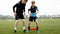 Teenage Boy With Soccer Coach on Stretching Session. Young Football Player Training With Stretching Bands