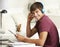 Teenage Boy Studying At Desk In Bedroom Using Digital Tablet