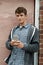 Teenage Boy Texting On Mobile Phone In Urban Setting