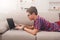 Teenage boy using laptop on couch at home