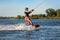 Teenage boy wakeboarding on river. Extreme water sport