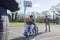 Teenage Boy In Wheelchair With Friends Playing Game Of Basketball In Park Together