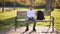 Teenage boy in white sweater sitting on the bench. Handsome school boy with backpack in autumn park