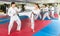 Teenage boy and woman sparring during group karate training