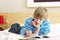 Teenage Boy Writing In Diary In Bedroom