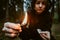 Teenage bully in hood holds burning match in his hand. Forest arsonist. Fire danger. Concept of arson and flame in night