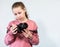 Teenage Caucasian girl looking at new big DSLR camera, first-timer in photography, grey background, copyspace