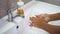 A teenage child washes his hands thoroughly with soap under running water in the sink. Clean your hands to prevent the