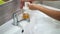 A teenage child washes his hands thoroughly with soap under running water in the sink. Clean your hands to prevent the